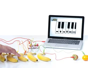 Makey Makey connected to bananas and a laptop piano